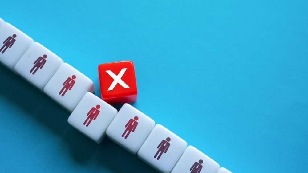 A stock photo of blocks arranged to illustrate layoffs