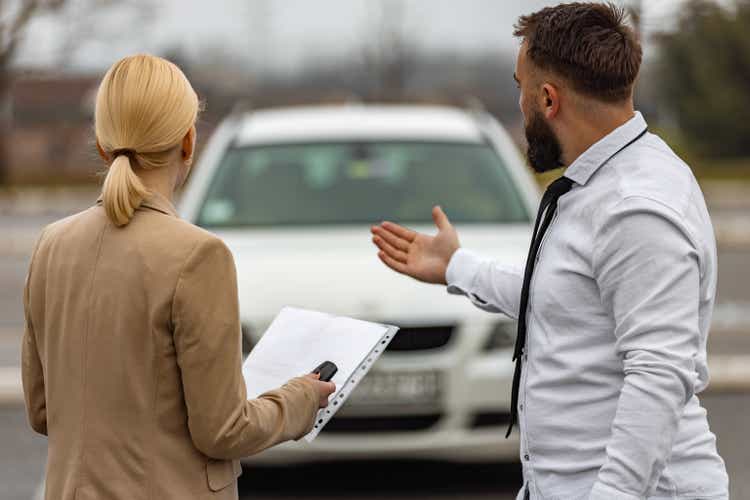 Couple on road trip standing by the car