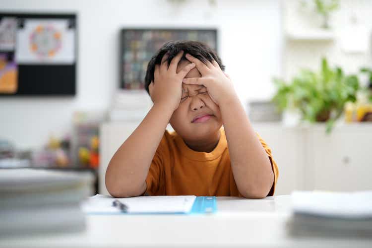 Worried young school boy studying at home