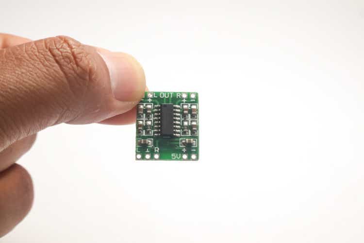 A small audio amplifier module held in one hand is used as DIY material for the electronics hobbyist.