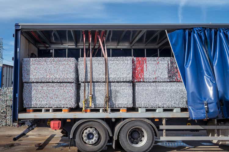 Bales of crushed clean cans on truck in aluminum can recycling factory