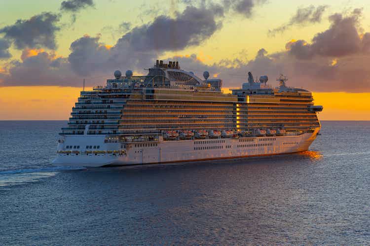 Cruise ship sailing off to tropical sunset.