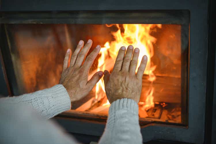 mature adult man lights up the fireplace