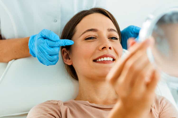 Beautiful Woman on Facial Treatment looking at mirror