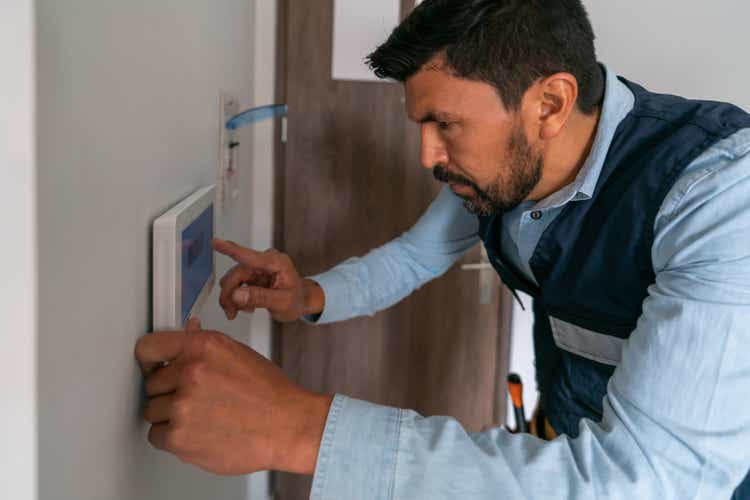 Technician installing an alarm system in a smart home