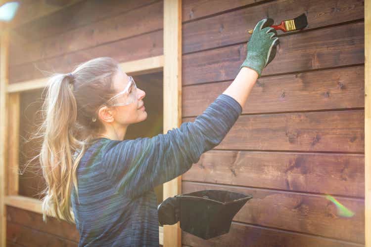 woman repairing a garden house