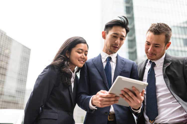 Японские бизнесмены, использующие планшет