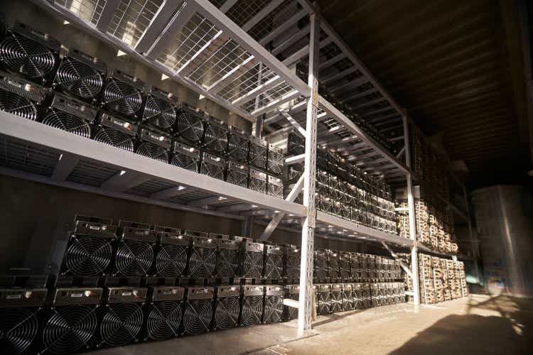 Биткойн-майнеры ASIC на складе. ASIC-майнинговое оборудование на стойках для добычи криптовалюты в стальном контейнере. Хранение интегральных схем для конкретных приложений технологии блокчейн