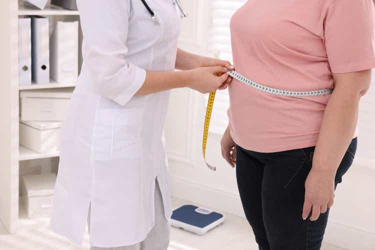 Nutritionist measuring overweight woman