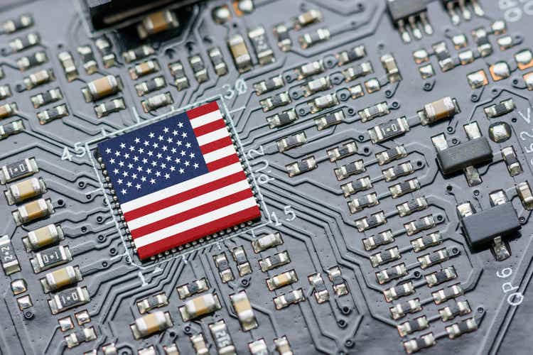 Флаг США на процессоре, центральном процессоре ЦП или микрочипе графического процессора на материнской плате.  Американские фирмы стали последним побочным ущербом в технологической войне между США и Китаем.  США блокируют продажу чипов искусственного интеллекта Китаю.