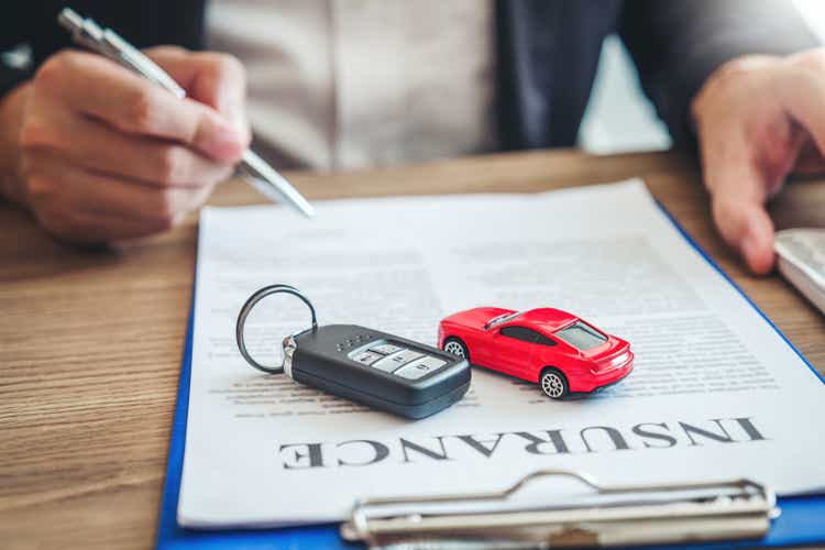 Агент по продаже заключает соглашение об успешном договоре автокредитования с клиентом и подписывает договор страхования. Концепция страхования автомобиля.