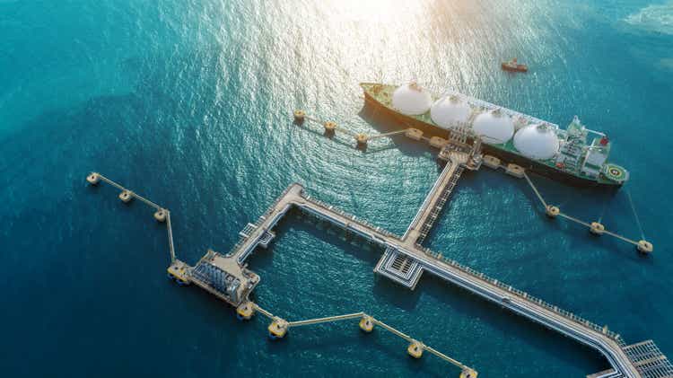 Танкер СПГ (сжиженный природный газ) стоит на якоре в газовых резервуарах газового терминала для хранения. Танкер для нефти и сырого газа. Сжиженный нефтяной газ в танкерном заливе, нефтехимический или метановый грузовой экспортно-импортный транспорт и логистика