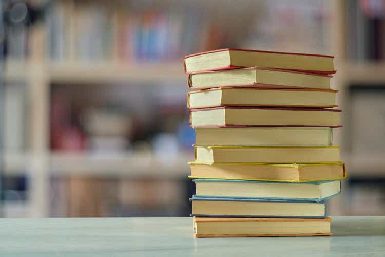 Стопка книг с размытым фоном книжной полки, чтение, обучение, образование или концепция домашнего офиса