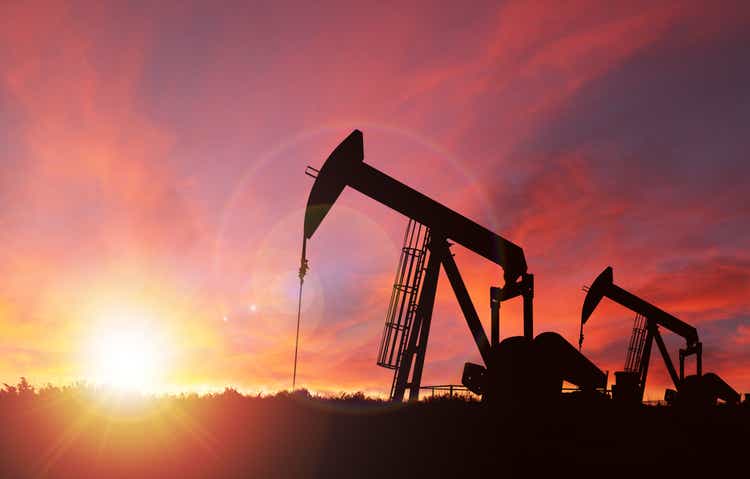 Закат над силуэтом Pumpjack с копией
