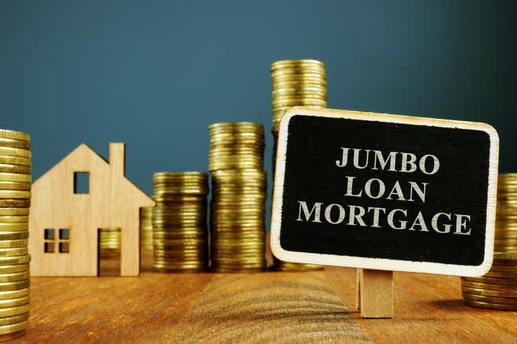 Ипотечная надпись Jumbo Loan и стопки монет.