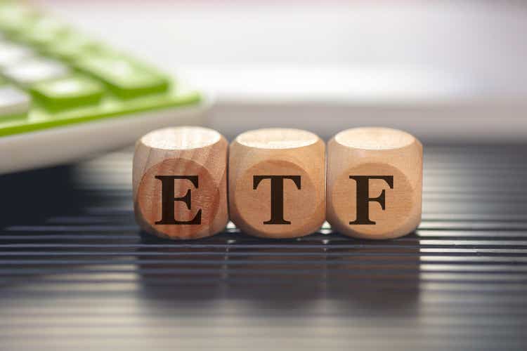 Акроним ETF для биржевого фонда, написанный на деревянных кубиках.  Калькулятор в составе.