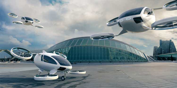 Три самолета eVTOL припаркованы и находятся в середине полета перед зданием терминала