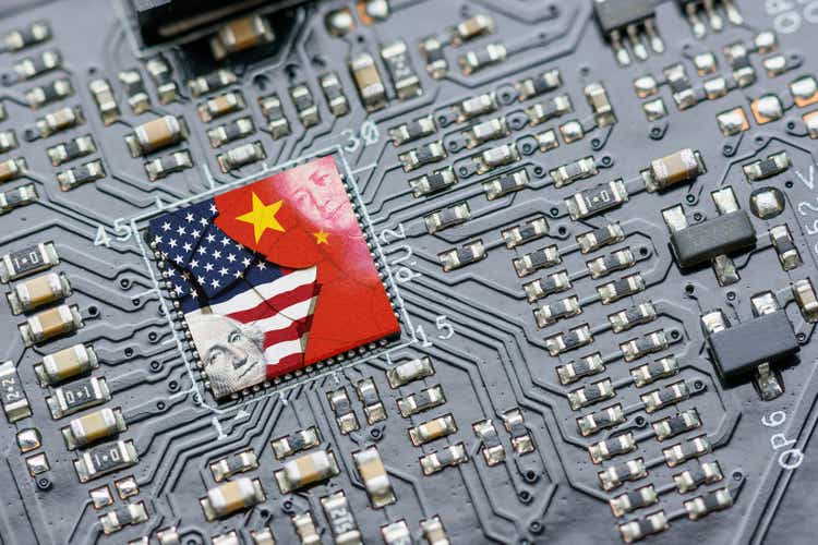 Флаг США и Китая на микрочипе процессора, ЦП или графического процессора на материнской плате.  Американские компании стали последним побочным ущербом в технологической войне между США и Китаем.  США ограничивают продажи чипов искусственного интеллекта в Китай.
