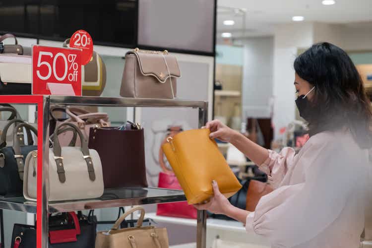 Китаянка проверяет выставленную на продажу кожаную сумочку
