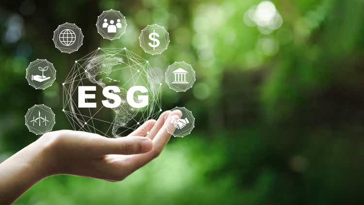 Концепция значка ESG в руке для экологического, социального и управления устойчивым и этическим бизнесом при сетевом соединении на зеленом фоне.