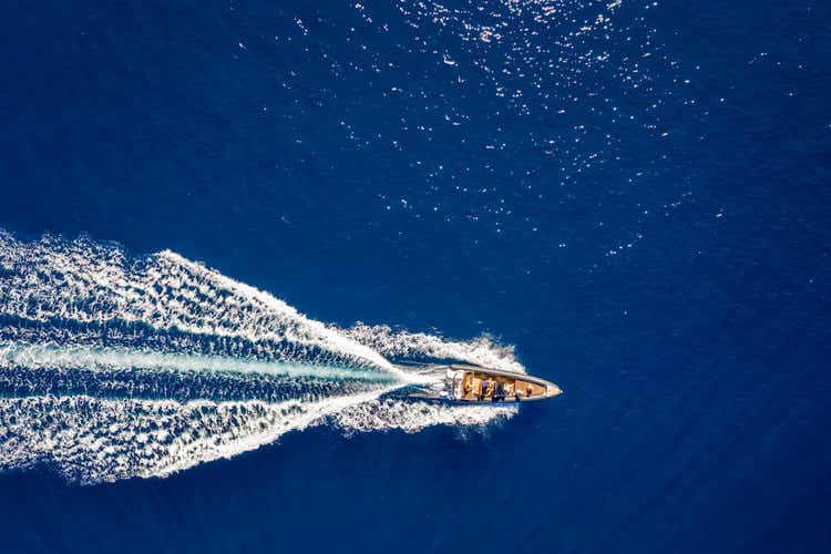Вид сверху вниз на моторную лодку, путешествующую по синему морю