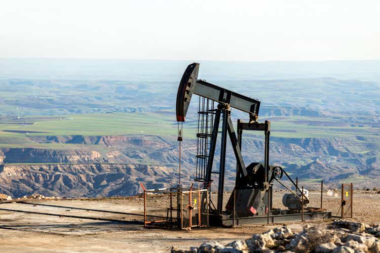 Вид на насосную станцию в нефтяной скважине нефтяного месторождения. Такое устройство обычно используется для наземных скважин, добывающих мало нефти. Пампджаки распространены в богатых нефтью районах.